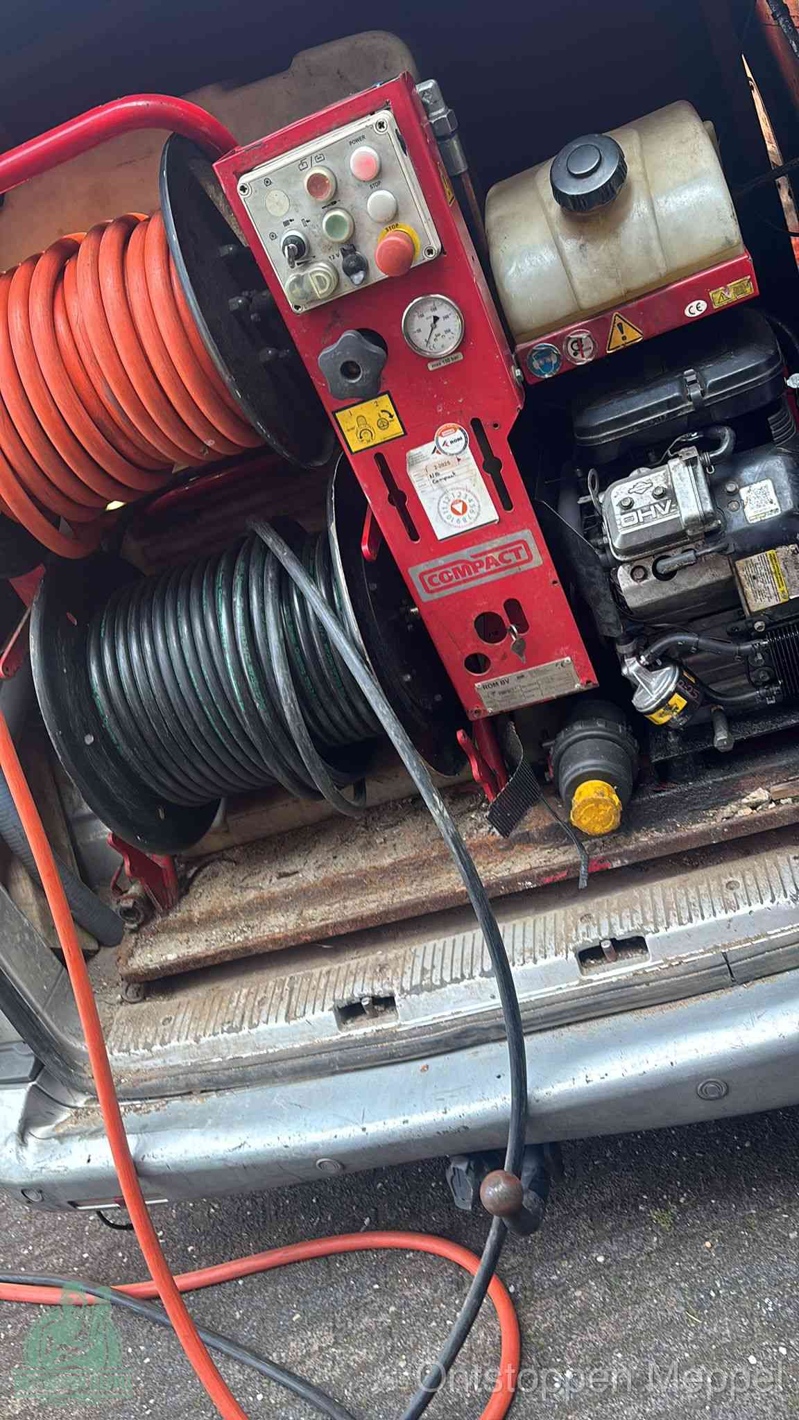 Een rood hogedruk-rioolreinigingstoestel in de laadbak van de bedrijfsbus, apparatuur voor een hardnekkige afvoerverstopping in Meppel