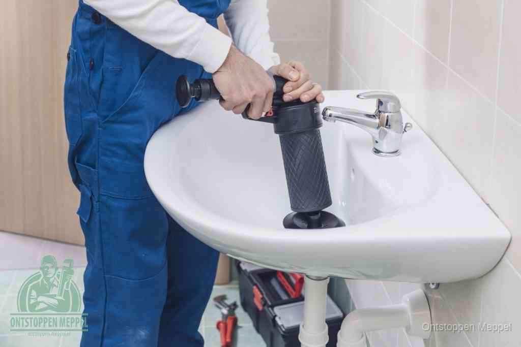 Een te ruwe doe-het-zelf poging met een hand-pomp op de afvoer van een badkamer-wastafel, een van de veelgemaakte fouten bij afvoer ontstoppen in Meppel