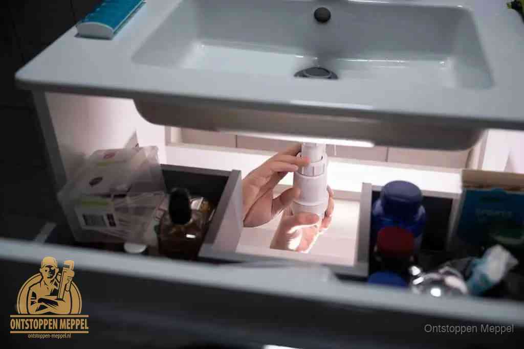 Een pompfles met zeep boven een wastafel in de toiletruimte, de warm water en afwasmiddel-methode om de wc te ontstoppen in Meppel Een pompfles met zeep boven een wastafel in de toiletruimte, de warm water en afwasmiddel-methode om de wc te ontstoppen in Meppel